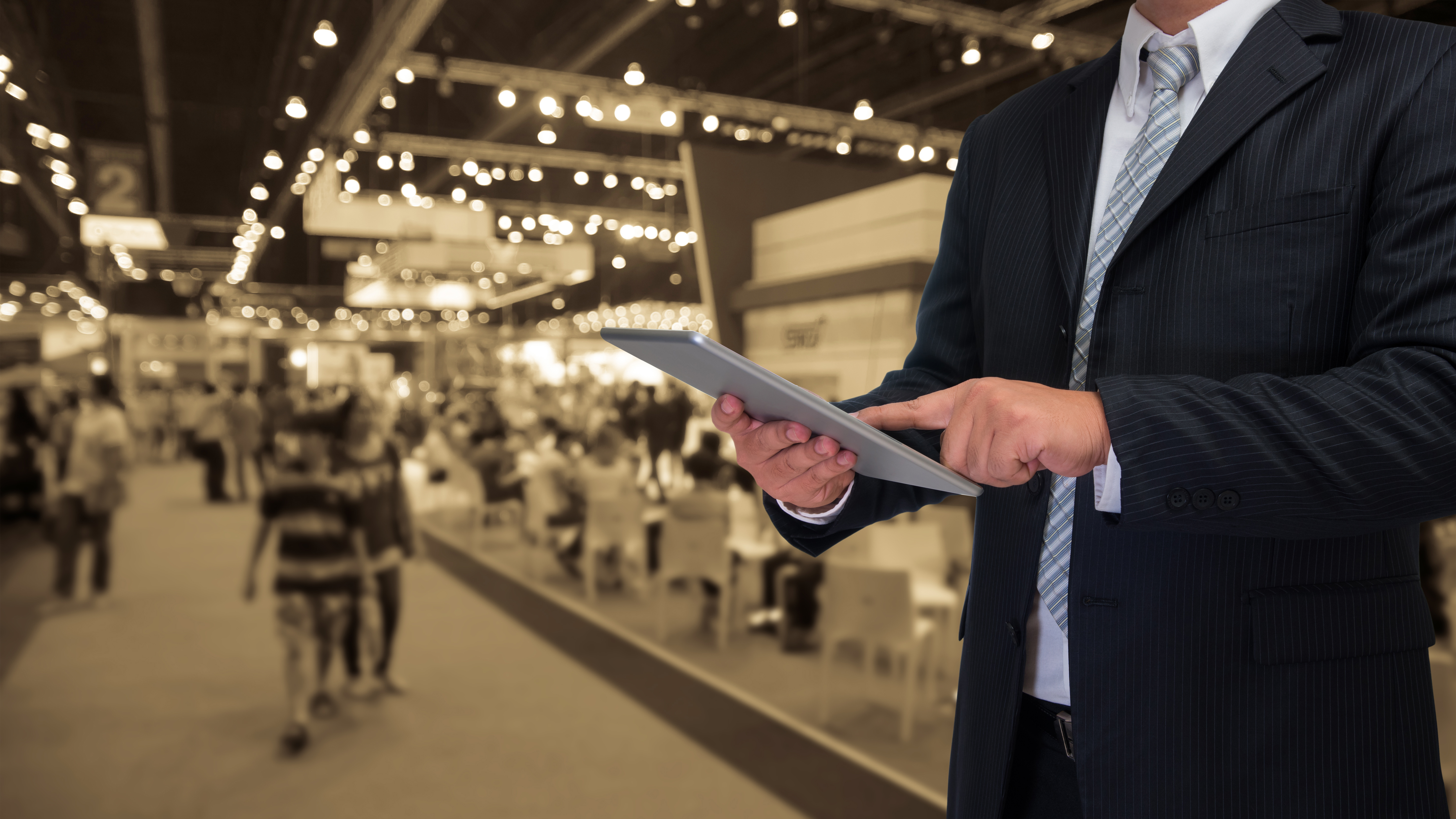 best digital marketing agency in uae businessman using tablet with blurred event background